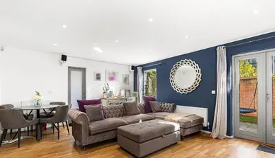 a living room with a couch and a table at Spacious 4 Bed house Perfect for Contractors-Relocators in Harlow
