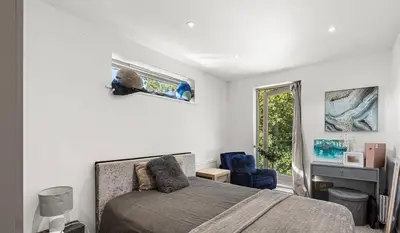 a bedroom with a bed and a chair and a window at Spacious 4 Bed house Perfect for Contractors-Relocators in Harlow