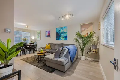 a living room with a couch and a dining room at Modern Comfort, Free Parking, Netflix & Disney plus in every Bedroom and Living Room in Shephall