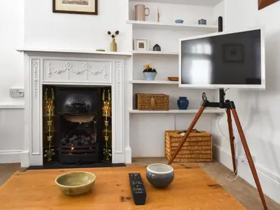 a living room with a television and a fireplace at Flock Cottage in Eye