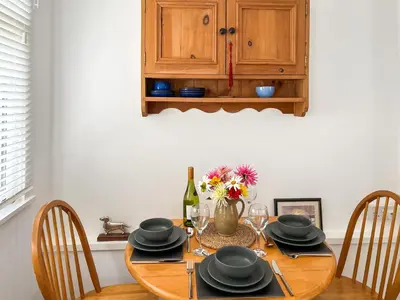 a dining room table with chairs and a bottle of wine at Flock Cottage in Eye