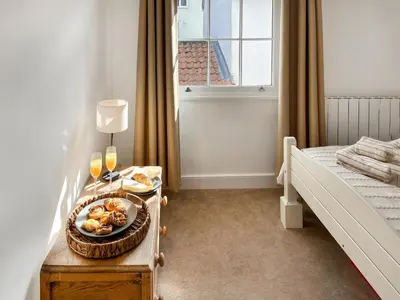a bedroom with a table with a plate of food on it at Flock Cottage in Eye