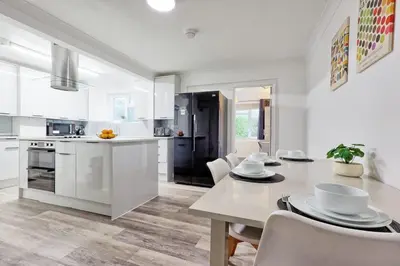 a kitchen and dining room with a table and chairs at Surehaven Stays 6 Bedroom House Great for Teams in Colchester