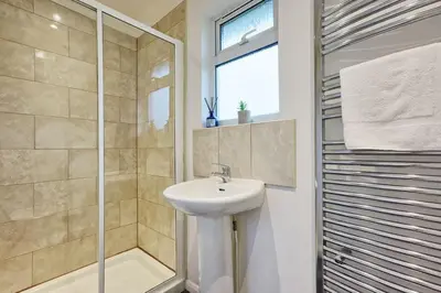 a white bathroom with a sink and a shower at Surehaven Stays 6 Bedroom House Great for Teams in Colchester