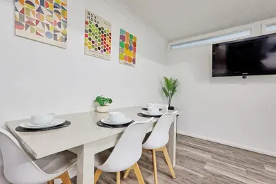 a dining room with a white table and chairs at Surehaven Stays 6 Bedroom House Great for Teams in Colchester