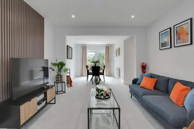 a living room with a blue couch and a tv at Surehaven Stays 3 Bedroom House Braintree in Braintree