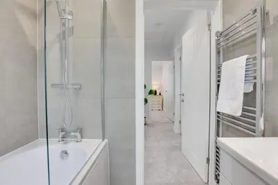 a white bathroom with a shower and a sink at Surehaven Stays 3 Bedroom House Braintree in Braintree