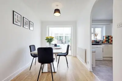 a kitchen and dining room with a table and chairs at Surehaven Stays 3 Bedroom House Braintree in Great Notley