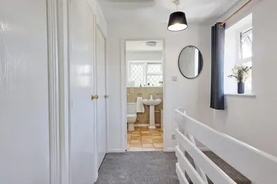 a white bathroom with a sink and a mirror at Surehaven Stays 3 Bedroom House Braintree in Great Notley