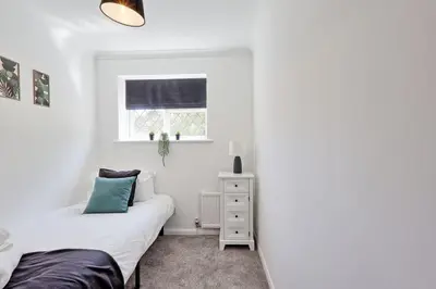 a white bedroom with a bed and a window at Surehaven Stays 3 Bedroom House Braintree in Great Notley