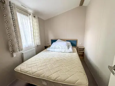 a small bedroom with a bed and a window at Lovely 8 Berth Caravan With Decking To Hire At Naze Marine In Essex Ref 17030Ga in Walton-on-the-Naze