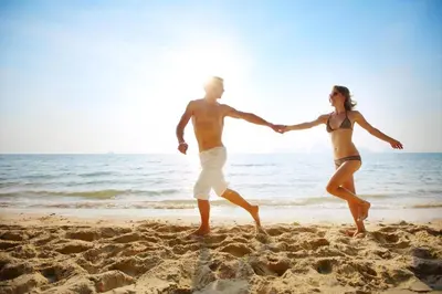 a man and a woman walking on the beach at Lovely 8 Berth Caravan With Decking To Hire At Naze Marine In Essex Ref 17030Ga in Walton-on-the-Naze