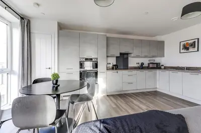 a kitchen with a table and chairs in a room at The Opulent Property Project ChelmsfordCityCentre 2Bed2Bath FreeParking Balcony in Chelmsford