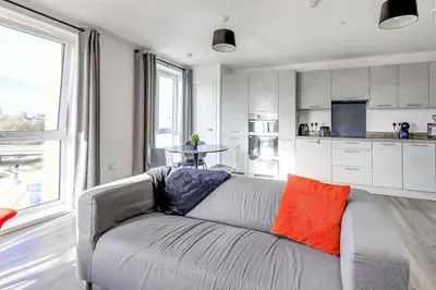 a living room with a couch and a kitchen at The Opulent Property Project ChelmsfordCityCentre 2Bed2Bath FreeParking Balcony in Chelmsford