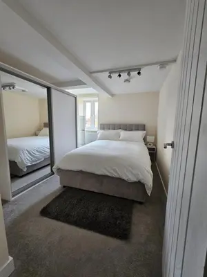 a bedroom with a large bed and a large mirror at Pancinos Guest House Newmarket High Street in Newmarket