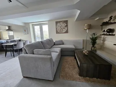 a living room with a couch and a table at Pancinos Guest House Newmarket High Street in Newmarket