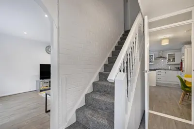 a staircase in a home with a white brick wall at Beautiful 3 bedroom house, Laindon, Basildon. in Laindon