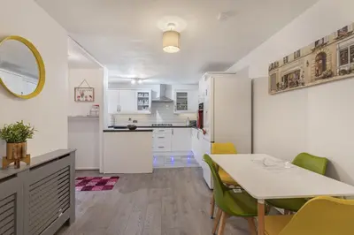 a kitchen and dining room with a table and chairs at Beautiful 3 bedroom house, Laindon, Basildon. in Laindon