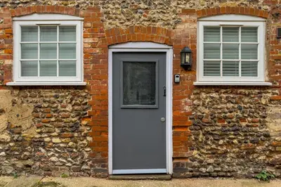 a brick building with a door and two windows at College Lane Apartment, Bury St Edmunds in Bury Saint Edmunds