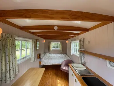 a small bedroom with a bed in a tiny house at Riverside Retreat in Little Baddow