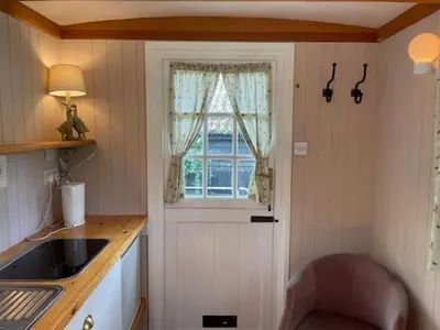a kitchen with a chair and a window and a sink at Riverside Retreat in Little Baddow
