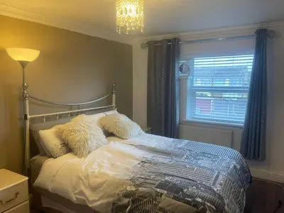 a bedroom with a bed with pillows and a window at Cassandra Homes in Nevendon