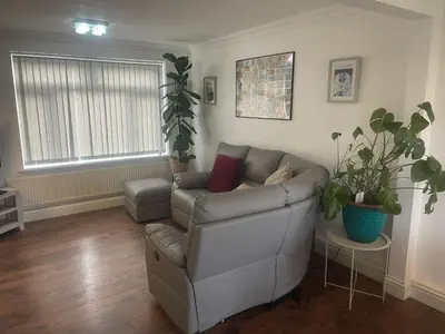 a living room with a couch and a plant at Cassandra Homes in Nevendon