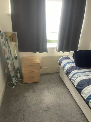 a bedroom with a bed and a dresser and a window at Cassandra Homes in Nevendon
