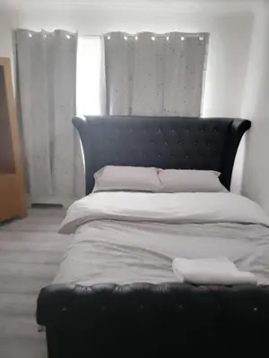 a bed with a black headboard in a bedroom at APEX HOUSE Le Hope ENSUITE in Horndon on the Hill