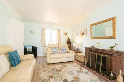 a living room with a couch and a fireplace at Rainbow Cottage in Thorpeness, Close to the Beach, Golf and the Country Club in Thorpeness
