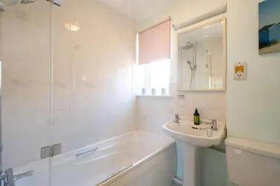 a bathroom with a tub and a sink and a shower at Rainbow Cottage in Thorpeness, Close to the Beach, Golf and the Country Club in Thorpeness
