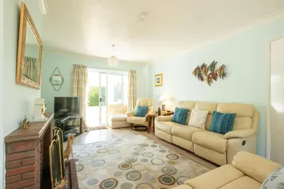 a living room with a couch and a tv at Rainbow Cottage in Thorpeness, Close to the Beach, Golf and the Country Club in Thorpeness