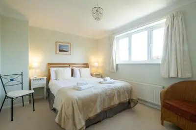 a bedroom with a large bed with towels on it at Rainbow Cottage in Thorpeness, Close to the Beach, Golf and the Country Club in Thorpeness