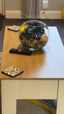 a bowl of fruit on a table with a remote control at Olivia's Cosy Cottage in Great Baddow