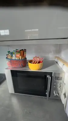 a microwave with a bowl of food on top of it at Olivia's Cosy Cottage in Great Baddow