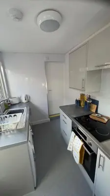 a white kitchen with a stove and a sink at Olivia's Cosy Cottage in Great Baddow
