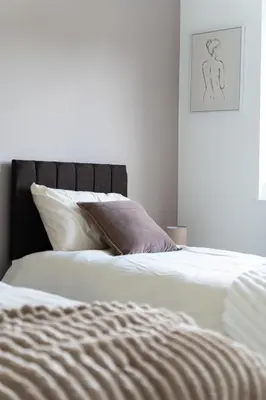 two beds in a bedroom with a drawing on the wall at Spacious 3-Bed Home with parking in Lexden