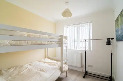 a bedroom with two bunk beds and a window at Spacious 3-Bed Home with parking in Lexden
