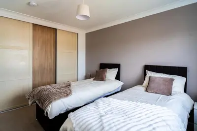 two beds sitting next to each other in a bedroom at Spacious 3-Bed Home with parking in Lexden