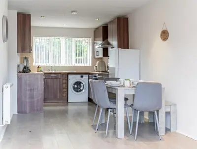 a kitchen with a table and chairs in a kitchen at Spacious 3-Bed Home with parking in Lexden