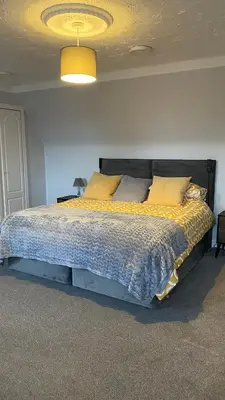 a bedroom with a large bed with yellow pillows at The cottage in Bury Saint Edmunds