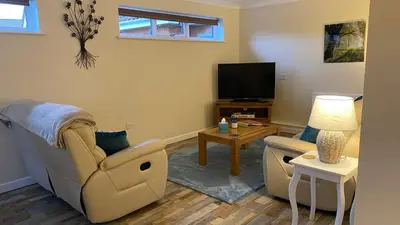 a living room with a couch and a tv at The cottage in Bury Saint Edmunds