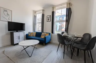 a living room with a blue couch and a table at 2 Bedroom Flat in the heart of Southend Sleeps 6 - Pass the Keys in Southend-on-Sea