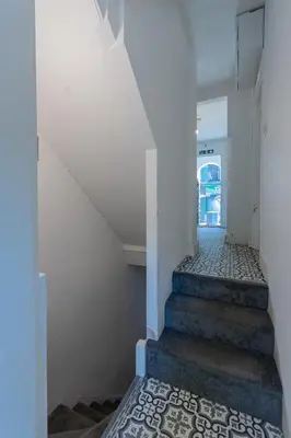 a stairway with a white wall and a blue and white tile floor at 2 Bedroom Flat in the heart of Southend Sleeps 6 - Pass the Keys in Southend-on-Sea