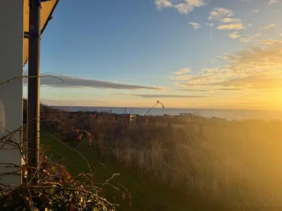 a view of the ocean at sunset from a field at Cottage on remote wild coast in Bawdsey