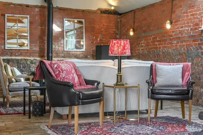 a living room with two chairs and a lamp at Scotland Hall Barn, Stoke by Nayland, Suffolk in Stoke by Nayland