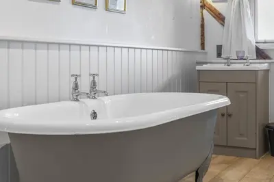 a white bath tub in a bathroom with a sink at Scotland Hall Barn, Stoke by Nayland, Suffolk in Stoke by Nayland