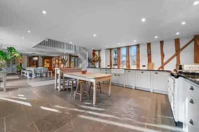 a kitchen with a wooden table and a dining room at Scotland Hall Barn, Stoke by Nayland, Suffolk in Stoke by Nayland