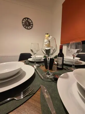 a table with glasses and plates and a bottle of wine at Nr Addenbrookes Large Hot Tub Stay Sleeps 10 in Barnwell Junction Station
