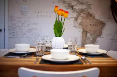 a table with plates and a vase of flowers on it at Stylish and Modern Flat with Free Parking - Pass the Keys in Cambridge